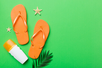Flat lay composition with flip flops and seashell on colored background. Space for text top view