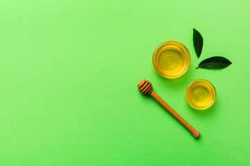 Honey jar with wooden honey dipper on white background top view with copy space. Delicious honey bottle