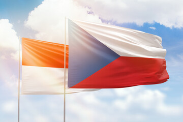 Sunny blue sky and flags of czechia and indonesia