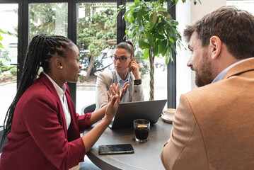 Group of young business freelancers people sitting in cafeteria on staff meeting discussing about...