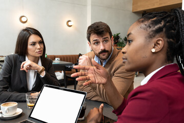 Group of young business freelancers people sitting in cafeteria on staff meeting discussing about future of their company. Colleagues having conversation about hiring new employee. Selective focus   