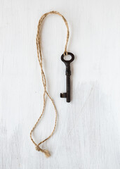 Art photo. Antique key on the white wooden background.