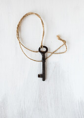 Old key on the wooden background. Art photo.