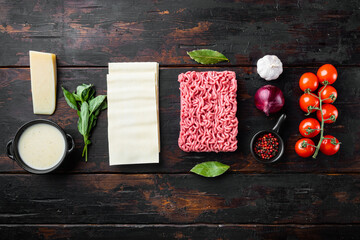 Ingredients for the preparation of Lasagna. Tomatoes, sauce, Bechamel, on old dark  wooden table background, top view, flat lay