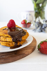 Homemade pancakes with red fruit and melted dark chocolate