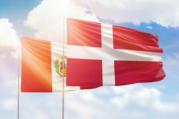 Sunny blue sky and flags of denmark and peru