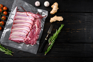 Lamb rib pack, on black wooden table background, top view flat lay, with copy space for text