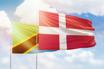 Sunny blue sky and flags of denmark and tanzania