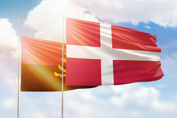 Sunny blue sky and flags of denmark and angola