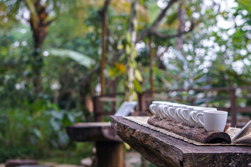 Coffee cups in nature. Selective focus coffee tasting in Bali, Indonesia on wooden table, forest in the background. Selective focus