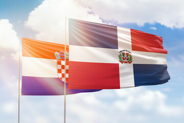 Sunny blue sky and flags of dominican republic and croatia