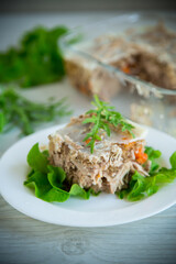 jellied meat with greens and vegetables in a plate