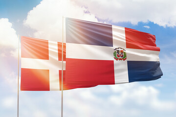 Sunny blue sky and flags of dominican republic and denmark
