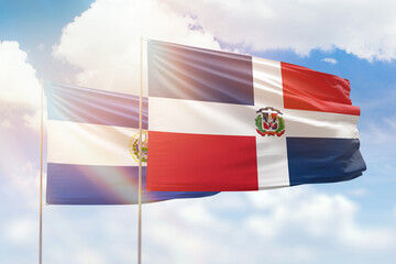 Sunny blue sky and flags of dominican republic and el salvador