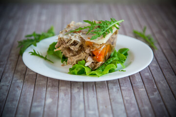 jellied meat with greens and vegetables in a plate