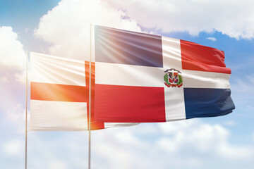 Sunny blue sky and flags of dominican republic and england