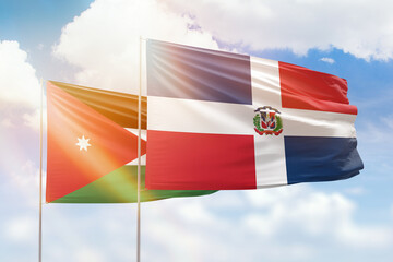 Sunny blue sky and flags of dominican republic and jordan