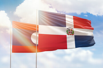 Sunny blue sky and flags of dominican republic and laos