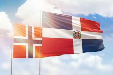 Sunny blue sky and flags of dominican republic and norway