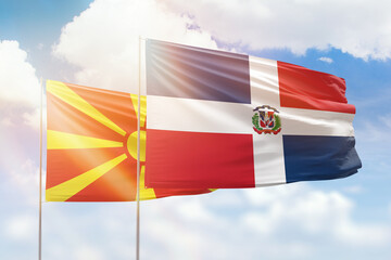Sunny blue sky and flags of dominican republic and north macedonia