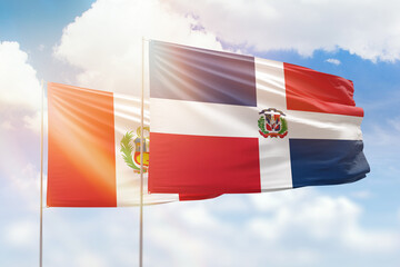 Sunny blue sky and flags of dominican republic and peru