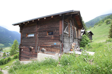 Wood barn on a green meadow in Switzerland.