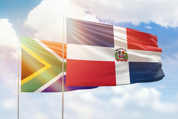 Sunny blue sky and flags of dominican republic and south africa