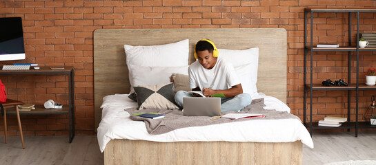 African-American guy  studying online at home