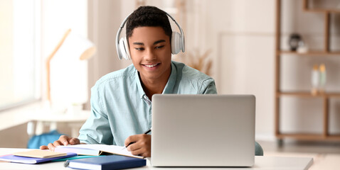 African-American guy studying online at home