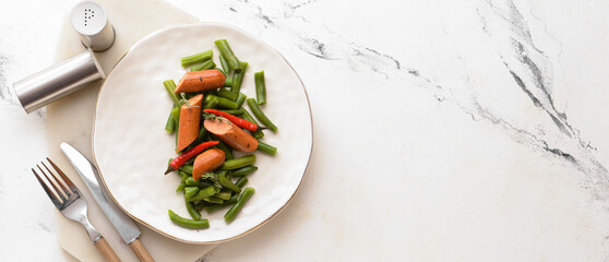 Plate with tasty sausage, green beans and chili pepper on light background with space for text, top...