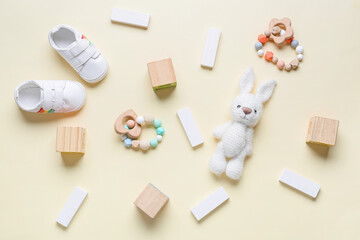 Children toys and booties on beige background