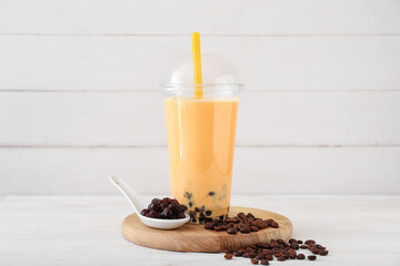 Plastic cup of tasty bubble tea on light background