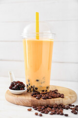 Plastic cup of tasty bubble tea on light background