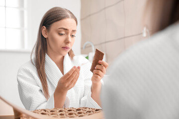 Young woman with hair loss problem  at home
