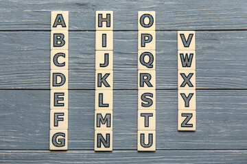 Different letters on grey wooden background. Alphabet concept