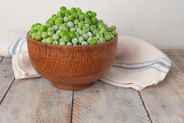 Young frozen green peas on wooden table viewed from above. Green pea pod table peas. Closeup of fresh green peas (Pisum sativum)