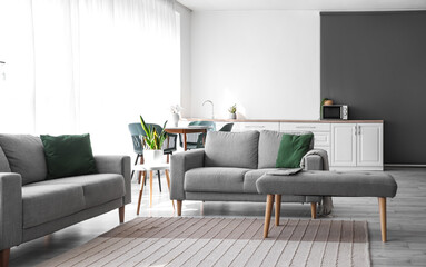 Interior of modern living room with sofas, dining table and bench