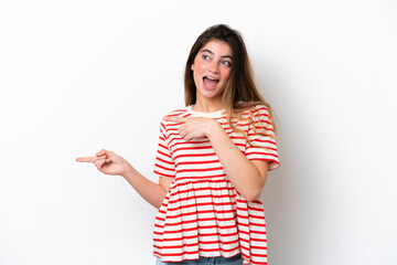 Young caucasian woman isolated on white background surprised and pointing side