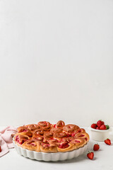 Baking dish with strawberry cinnamon rolls on white background