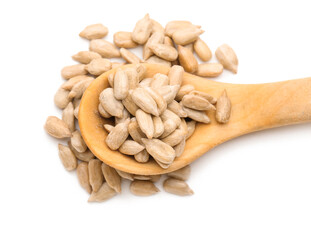 Wooden spoon and peeled sunflower seeds on white background, closeup