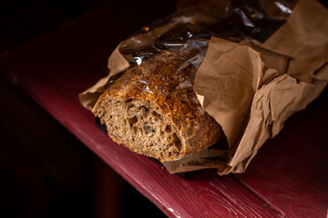 Buckwheat baguette. Sliced baguette made from dark coarse flour. Dark background.