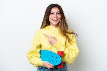 Fototapeta na wymiar Young caucasian woman isolated on white background with a skate and pointing to the side