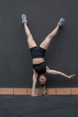 Sportswoman doing one arm handstand