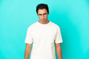 Caucasian handsome man over isolated blue background with sad expression