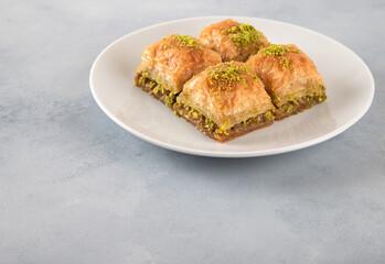  Pistachio baklava on a white plate.Traditional Turkish baklava on a white background
