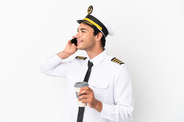 Airplane pilot over isolated white background holding coffee to take away and a mobile