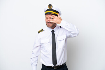 Airplane middle age pilot isolated on white background covering eyes by hands and smiling