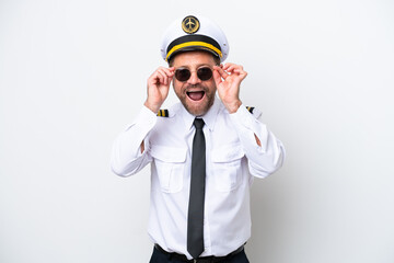 Airplane middle age pilot isolated on white background with glasses and surprised