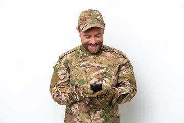 Military man isolated on white background sending a message with the mobile