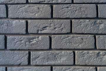 Wall is made of gray bricks. Abstract background. Rough textured surface. Grunge or loft style.